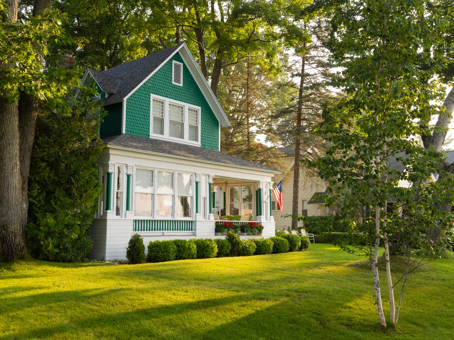 Corner view of green and white summer house on Lake Michigan.