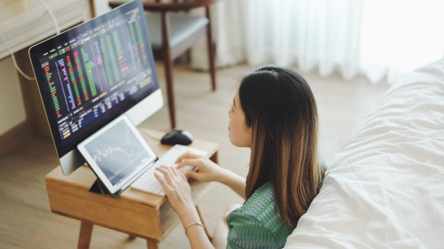 Woman interacts with an AI-powered investment assistant on her tablet and phone investing, robo-advisors, and AI-based finance tools for crypto-savvy Gen Z investors. 2026