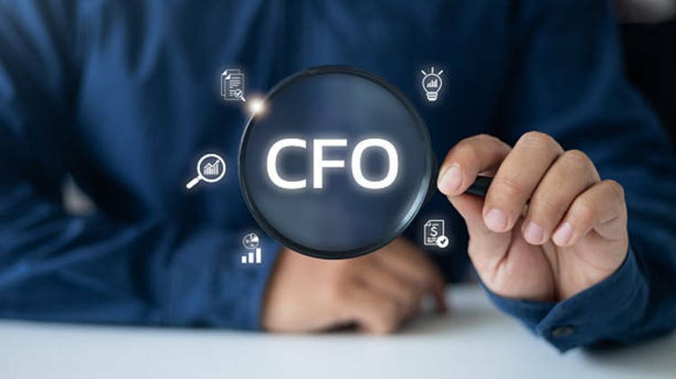Businessman holding a magnifying glass, highlighting the CFO role with financial icons, representing executive leadership in corporate finance, strategy, and accounting.