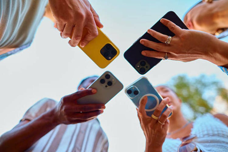 Group of friends sharing content on their smartphones