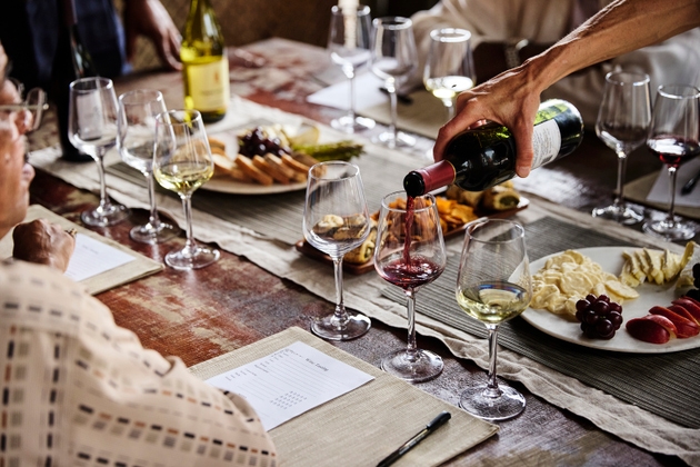 Sommelier pouring red wine into glass during tasting dinner