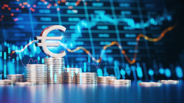 Euro Symbol On Top Of Stacks of Coins In Front Of a Financial Chart in the Background