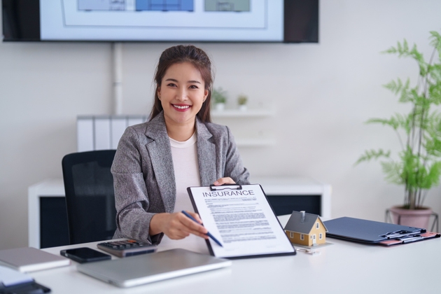 Asian adult woman insurance agent present home policy property protection smiling modern office professional sales advisor client consultation real estate services
