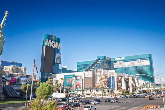 MGM Grand Resort on the Las Vegas Strip, featuring teal glass towers, the MGM golden lion statue and large billboards, MGM Resorts International is a hotel chain in the United States.