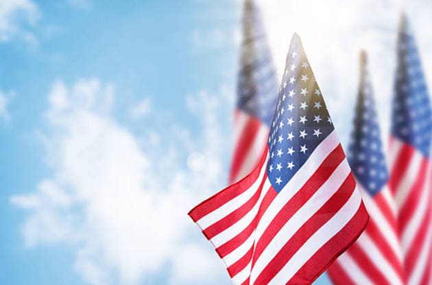 USA flag background for Veterans Day, Memorial Day, Independence Day, and 4th of July designs. American flags waving on blue sky background, symbolizing patriotism, freedom, and national pride.
