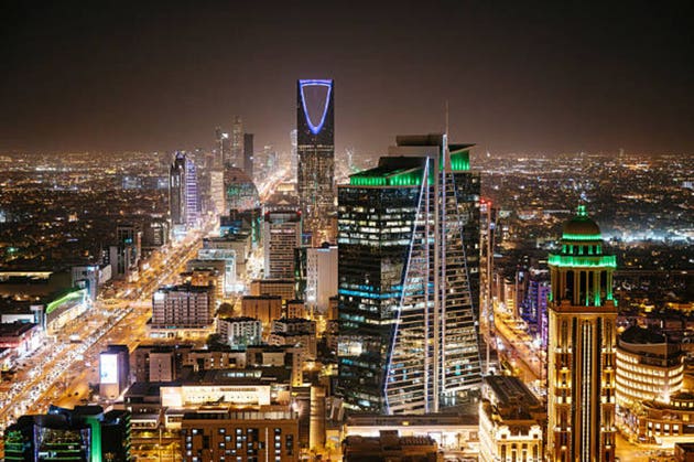 Aerial view of Riyadh at night with illuminated modern skyscrapers and busy streets under a clear dark sky, Al Olaya street