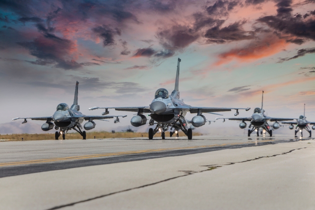 F-16 Fighter Jets doing elephant walk on runway at sunset