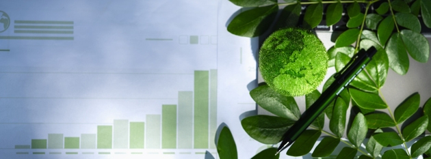 Eco-friendly business concept with green earth model, laptop, leaves, and analytics charts. Symbolizes sustainability, green innovation, and environmental responsibility in modern workspaces.
