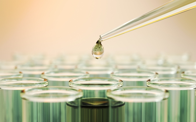 Testing Liquid from Green Glass Pipette into Test Tubes on Yellow Reflective Background