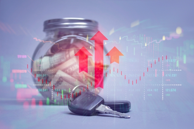 Transparent glass jar filled with money and car keys overlaid with red upward arrows and stock market charts. The concept represents savings growth, financial investment success.