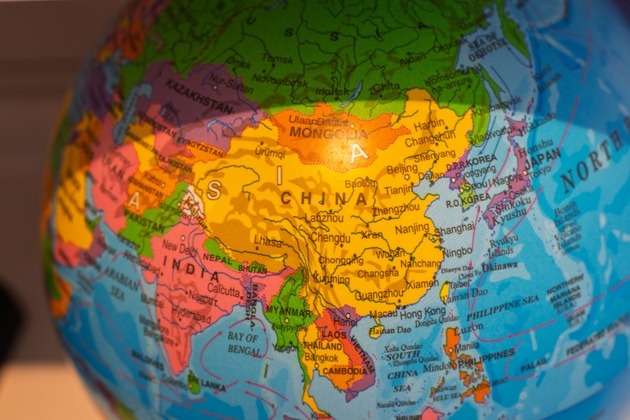 Geographic globe showing china and other asian countries spreading across the world a educational concept