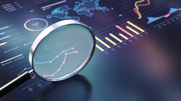 Magnifying Glass Over Data Analytics Dashboard Showcasing Market Trends and Business Insight