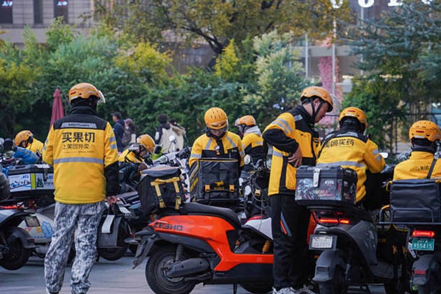 Popular FOOD DELIVERY SERVICE MEITUAN WAIMAI in Chengdu. Staff of Takeaway Service riding on motorcycle to deliver food.