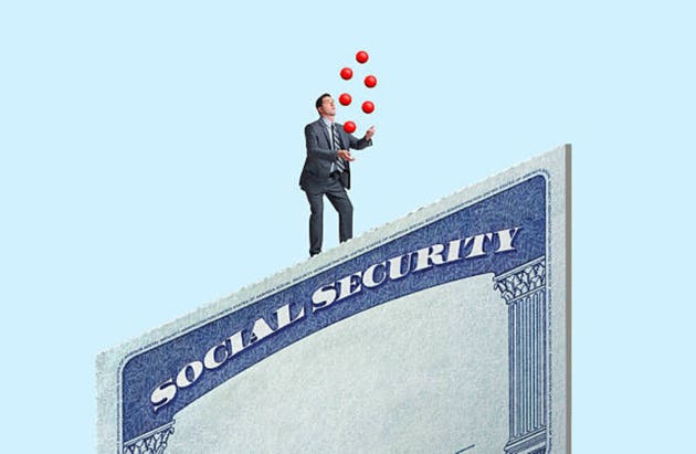 A man juggles as he stands on top of a large Social Security card