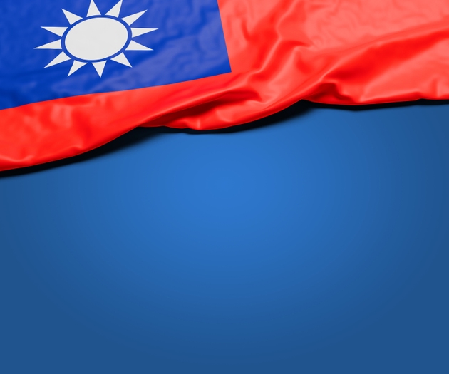 The wrinkled flag of Taiwan draped onto a flat blue background with shadow. Copy space for message