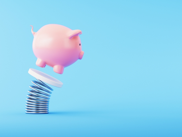 Piggy bank Jumping on Coiled Spring over Blue Background.