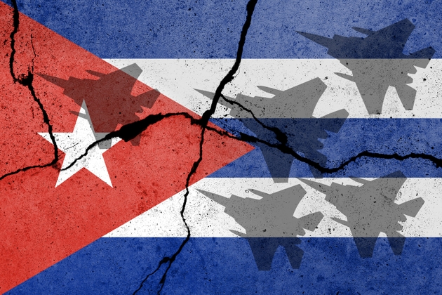 Flag of Cuba painted on a concrete wall with airplane shadows