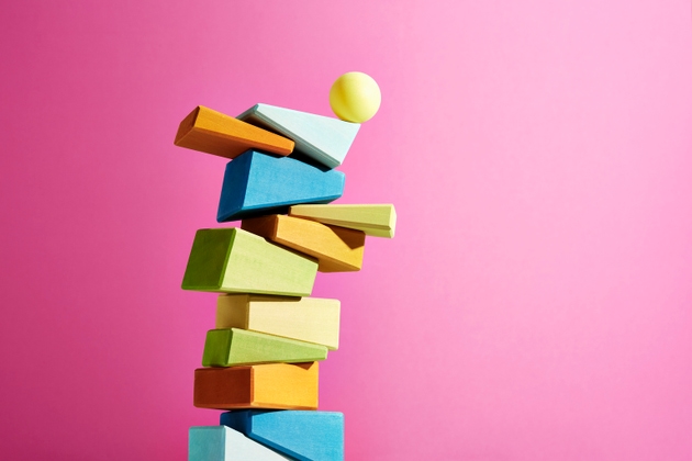 Yellow sphere on top of an unstable stack of irregular shaped geometric objects