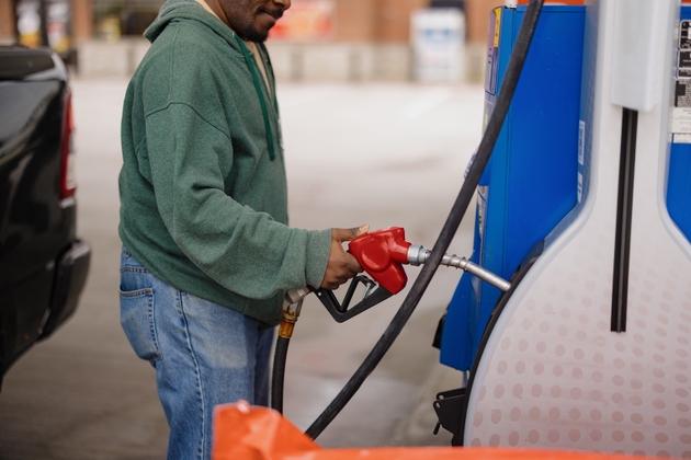 Man fueling vehicle at gas station pump