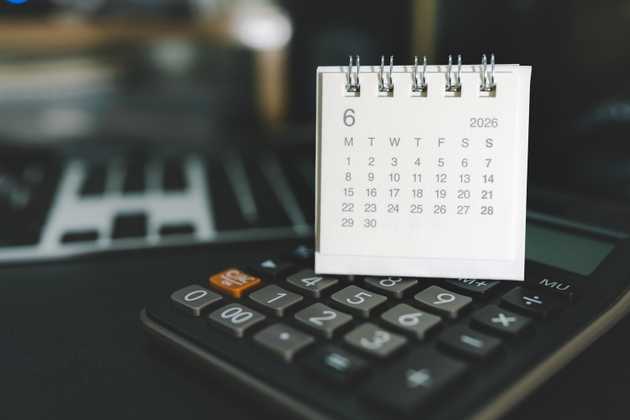 JUNE 2026 Desk Calendar on Digital Calculator for Financial Planning. Financial budgeting, tax season preparation, and scheduling business deadlines in a professional workspace setting.