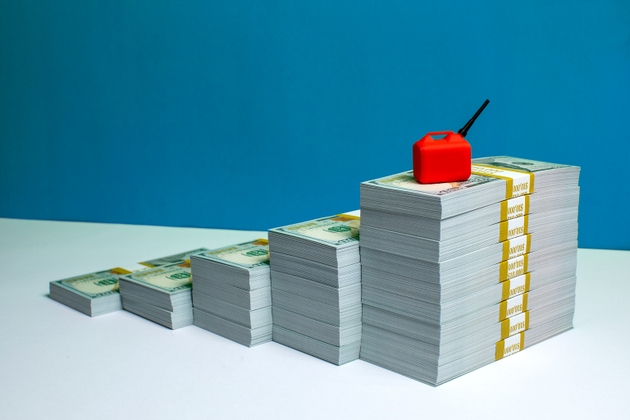 Rising Stacks of Money with Gas Can on Top Representing Fuel Costs