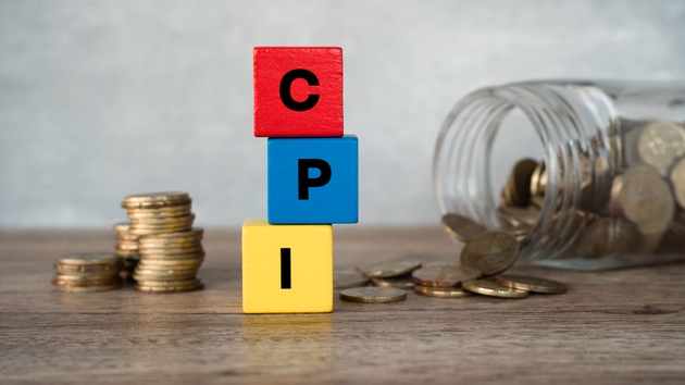 CPI Consumer Price Index acronym on wooden blocks with glass jar of coins and calculator in background