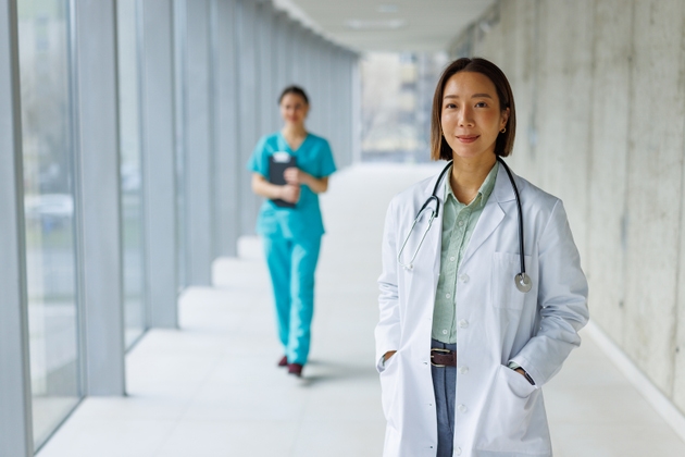 Female doctor smiling in hospital corridor with colleague