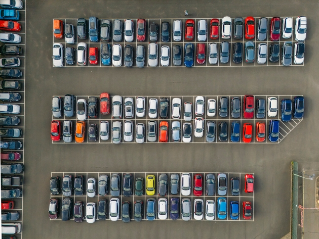 An overhead aerial/drone view down onto cars in a car park