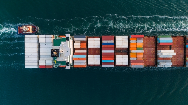 An overhead aerial/drone view of a container ship at sea