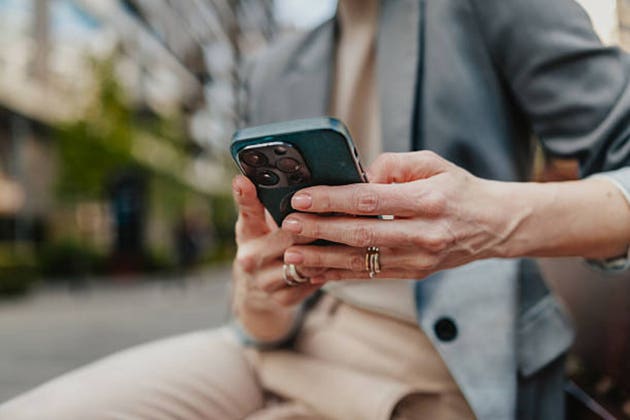 Close-up of businesswoman using smartphone outdoors in city