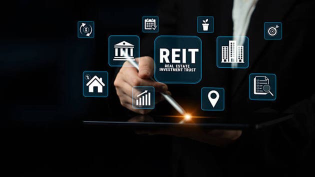 Hand Holding Tablet with REIT Symbol and Icons Representing Real Estate Investment Trust, Technology, Finance, and Business Concepts