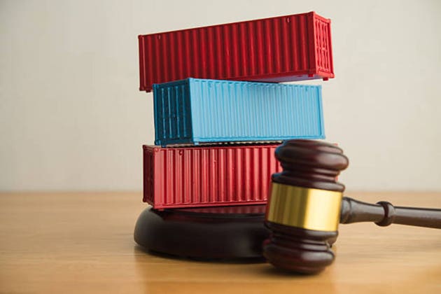 Shipping cargo containers and hammer judge gavel on table.