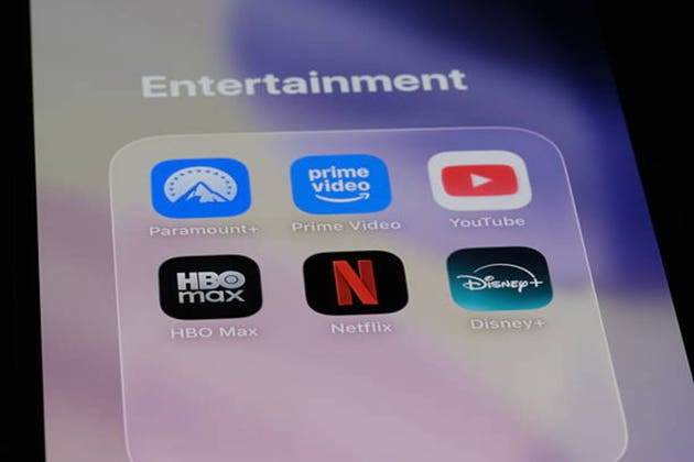 smartphone screen displaying streaming service application icons. Netflix, disney+, hbo max, youtube, prime video, paramount+