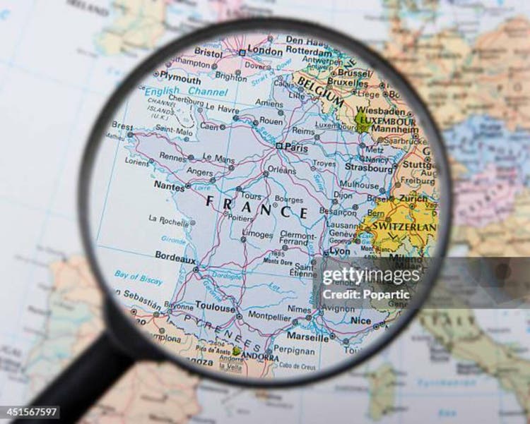 A magnifying glass over a map focusing on France