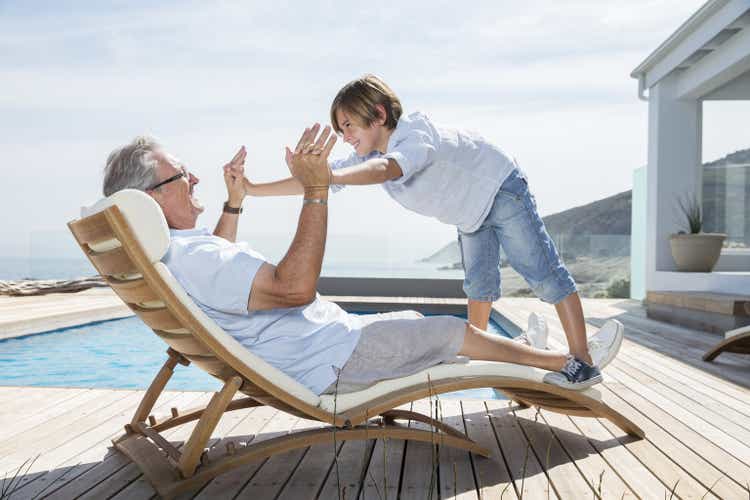 Grandfather and grandson playing at poolside