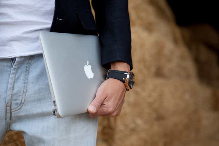 male is holding MacBook Air