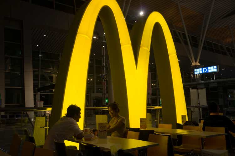 Smiling asian couple eating in McDonalds restaurant