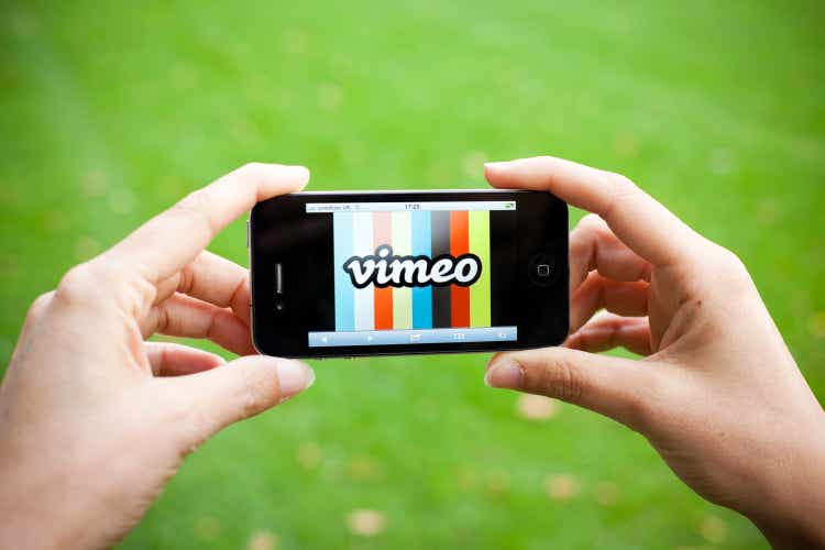 Hands Holding Iphone 4 with Vimeo