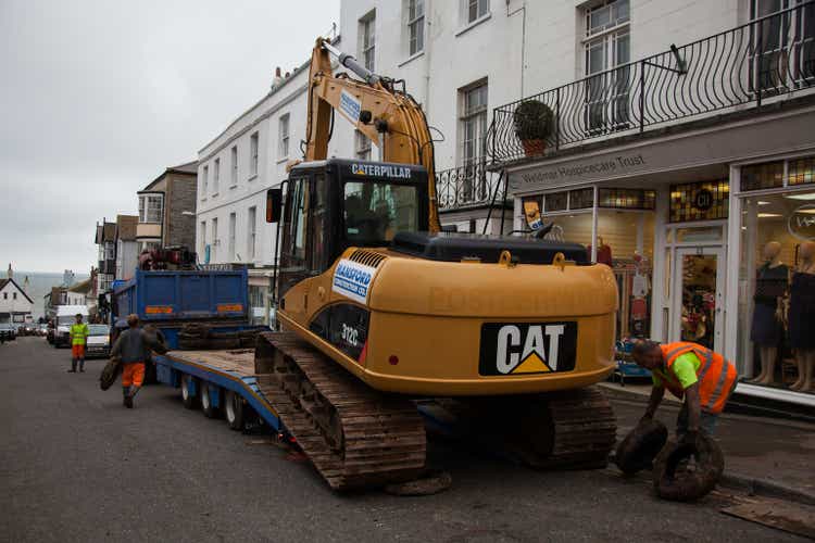 CAT Caterpillar earth mover is loaded onto a blue trailer