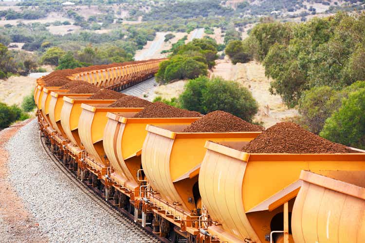 Train loaded with brown hematite iron ore in hills