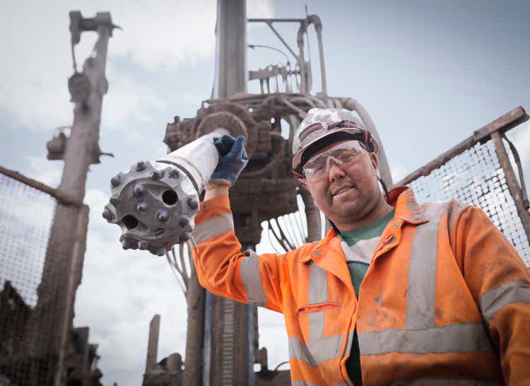 Portrait of drilling rig worker in hard hat and workwear