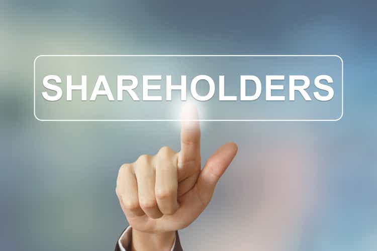 business hand clicking shareholders button on blurred background