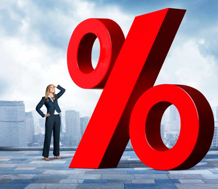 Businesswoman With Hand On Head Looking Up At Percentage Sign