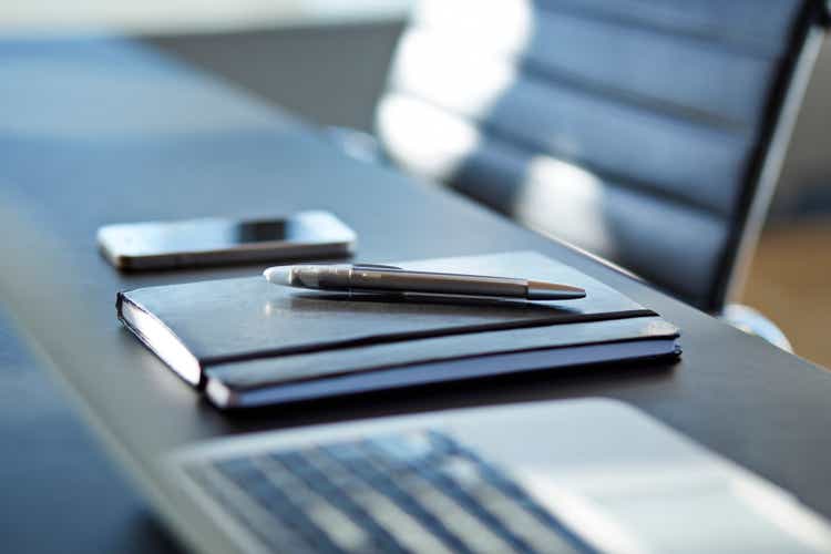 Close-up of notebook with pen on top,phone in back