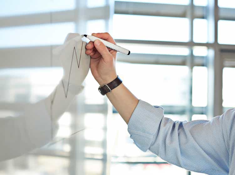 Hand draws graph on whiteboard
