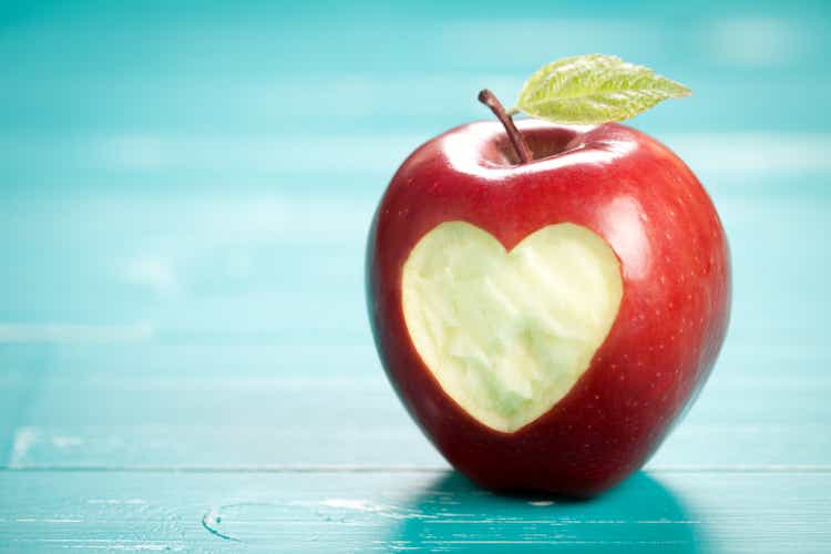 Apple with heart on turquoise table