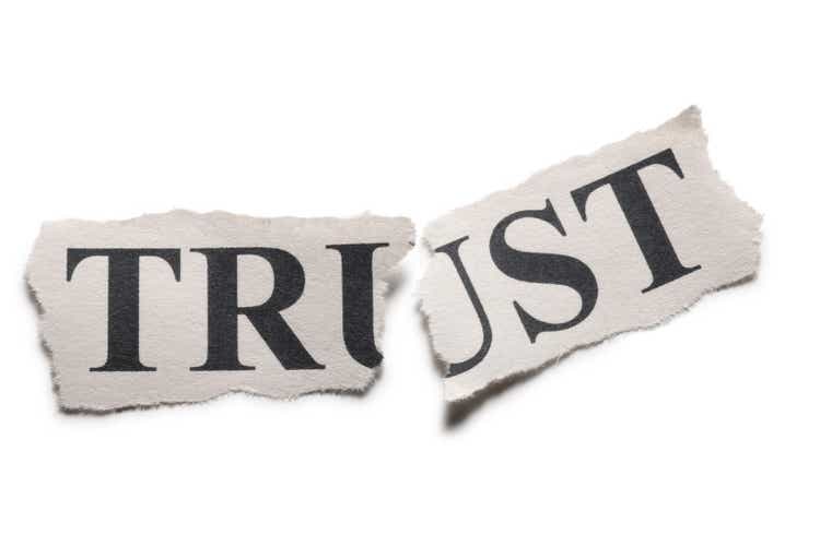 The word trust printed on paper torn in half
