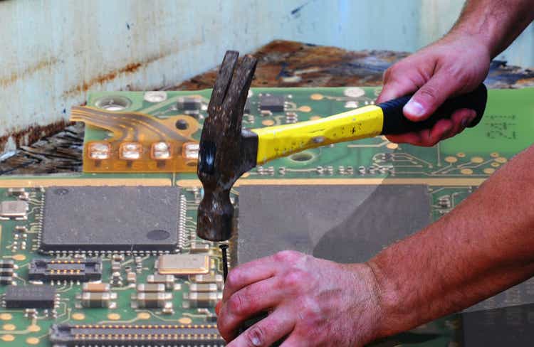 Computer maintenance with hammer and nail and microchip