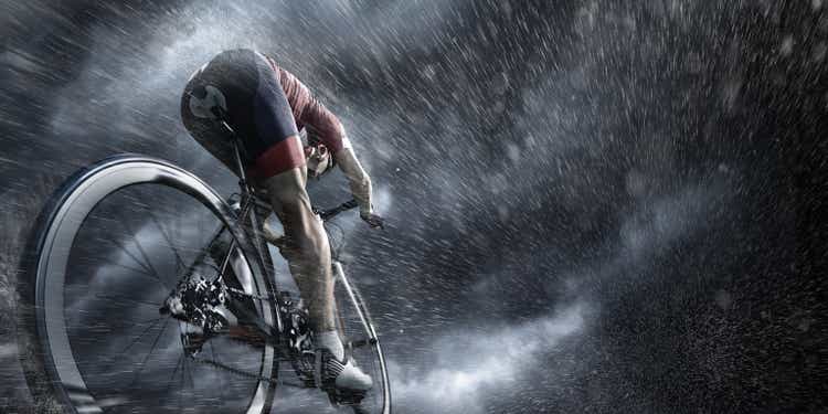 Professional cyclist under stormy sky