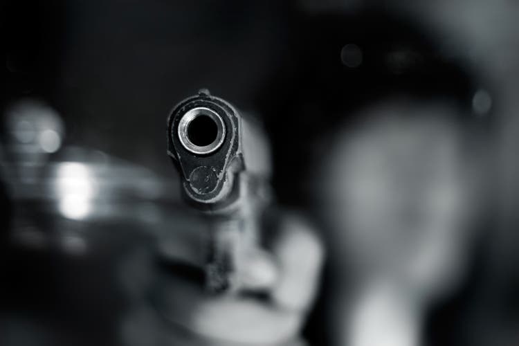 Black and white, woman pointing old gun to front